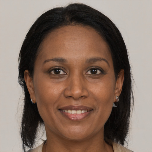 Joyful black adult female with medium  brown hair and brown eyes