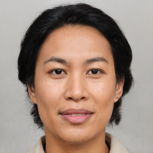 Joyful asian adult female with medium  black hair and brown eyes