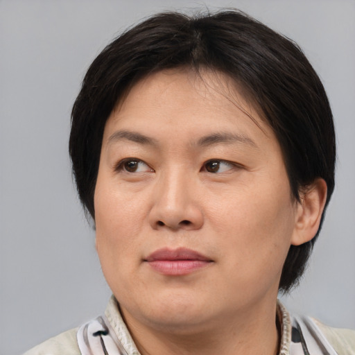 Joyful asian adult female with medium  brown hair and brown eyes