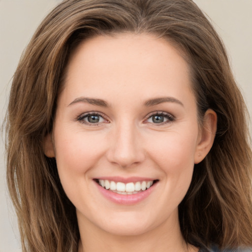 Joyful white young-adult female with long  brown hair and grey eyes