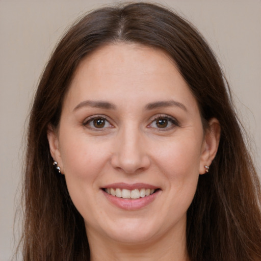 Joyful white adult female with long  brown hair and brown eyes