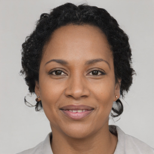 Joyful black adult female with short  black hair and brown eyes