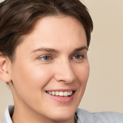 Joyful white young-adult female with short  brown hair and grey eyes