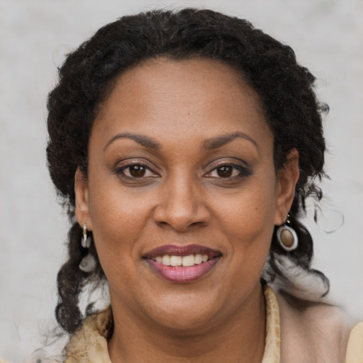 Joyful black adult female with medium  brown hair and brown eyes
