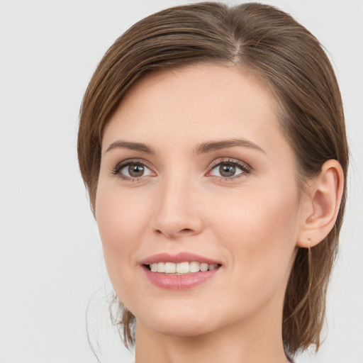 Joyful white young-adult female with medium  brown hair and grey eyes