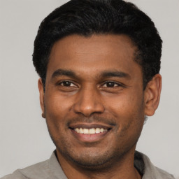 Joyful latino young-adult male with short  black hair and brown eyes