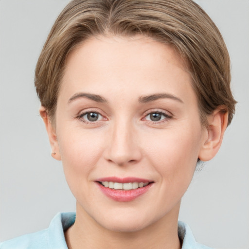 Joyful white young-adult female with short  brown hair and grey eyes