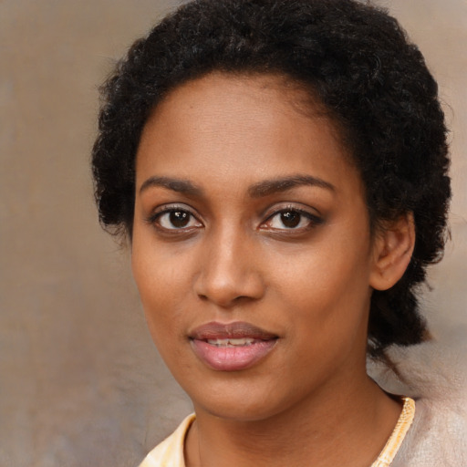 Joyful black young-adult female with short  brown hair and brown eyes