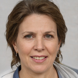 Joyful white adult female with medium  brown hair and grey eyes