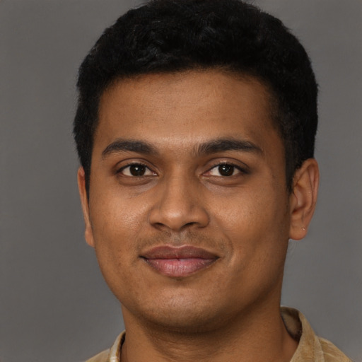 Joyful black young-adult male with short  brown hair and brown eyes