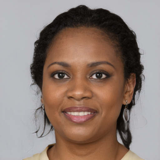 Joyful black young-adult female with long  brown hair and brown eyes