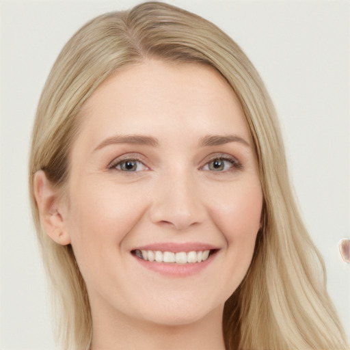 Joyful white young-adult female with long  blond hair and blue eyes