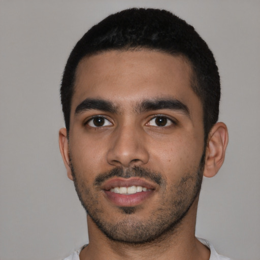 Joyful latino young-adult male with short  black hair and brown eyes