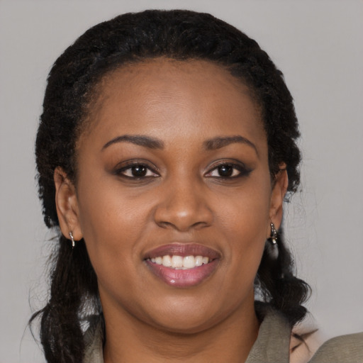 Joyful black young-adult female with long  black hair and brown eyes