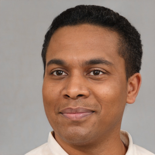 Joyful black young-adult male with short  black hair and brown eyes