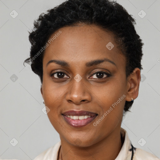 Joyful black young-adult female with short  black hair and brown eyes