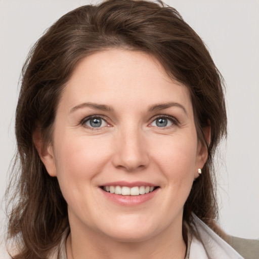 Joyful white young-adult female with medium  brown hair and grey eyes