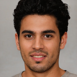 Joyful latino young-adult male with short  brown hair and brown eyes