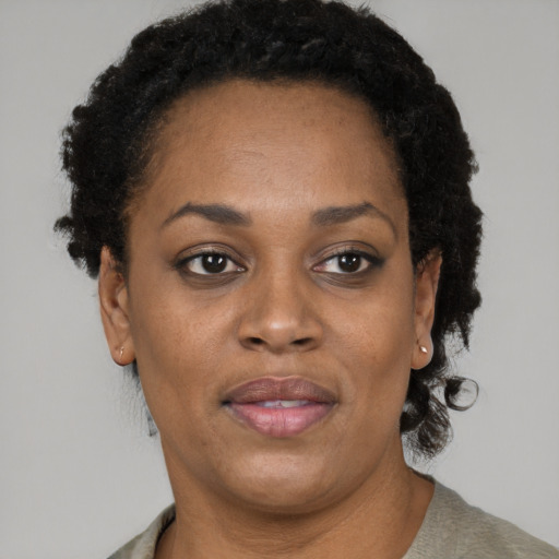 Joyful black adult female with short  brown hair and brown eyes