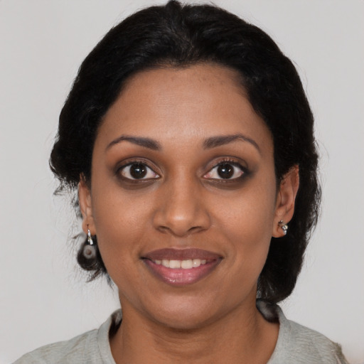 Joyful black young-adult female with medium  black hair and brown eyes