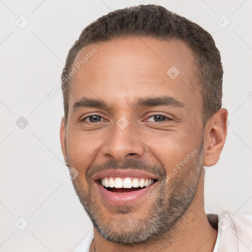 Joyful white young-adult male with short  brown hair and brown eyes