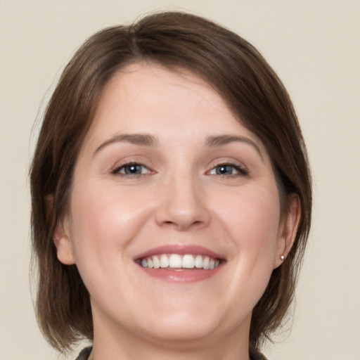 Joyful white young-adult female with medium  brown hair and blue eyes