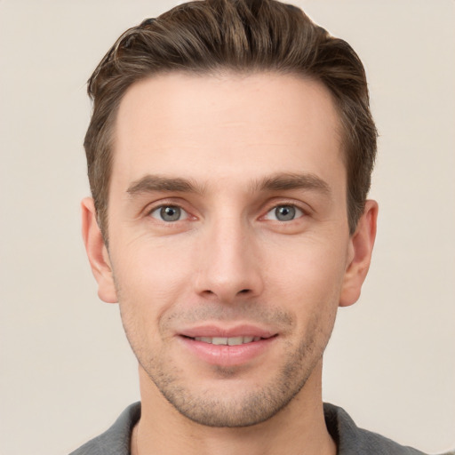 Joyful white young-adult male with short  brown hair and grey eyes