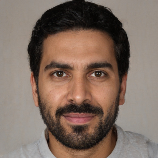 Joyful white young-adult male with short  black hair and brown eyes