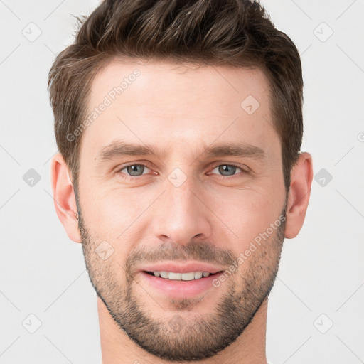 Joyful white young-adult male with short  brown hair and grey eyes