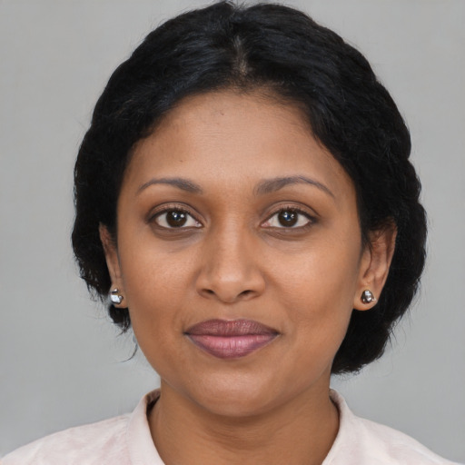 Joyful black adult female with medium  brown hair and brown eyes