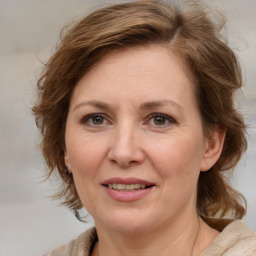 Joyful white adult female with medium  brown hair and blue eyes