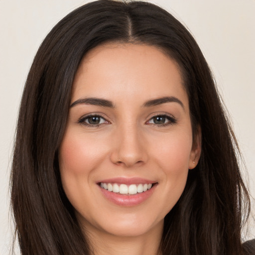 Joyful white young-adult female with long  brown hair and brown eyes