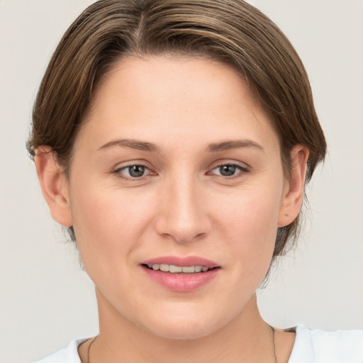 Joyful white young-adult female with medium  brown hair and grey eyes