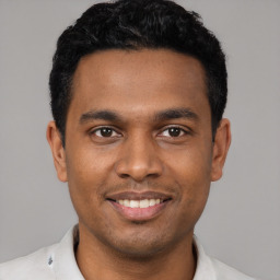 Joyful latino young-adult male with short  black hair and brown eyes