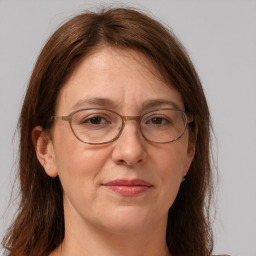 Joyful white adult female with long  brown hair and grey eyes