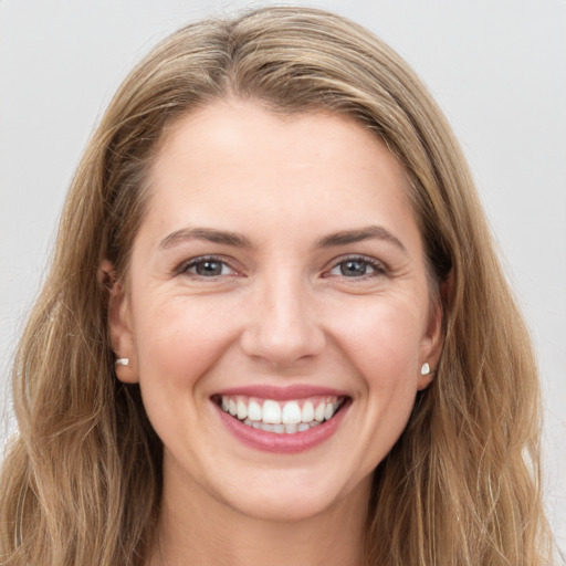 Joyful white young-adult female with long  brown hair and grey eyes