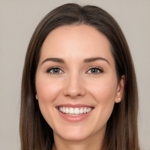 Joyful white young-adult female with long  brown hair and brown eyes