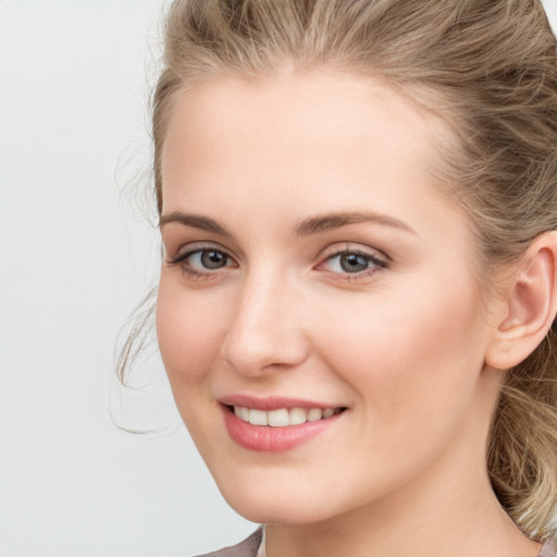 Joyful white young-adult female with long  brown hair and blue eyes