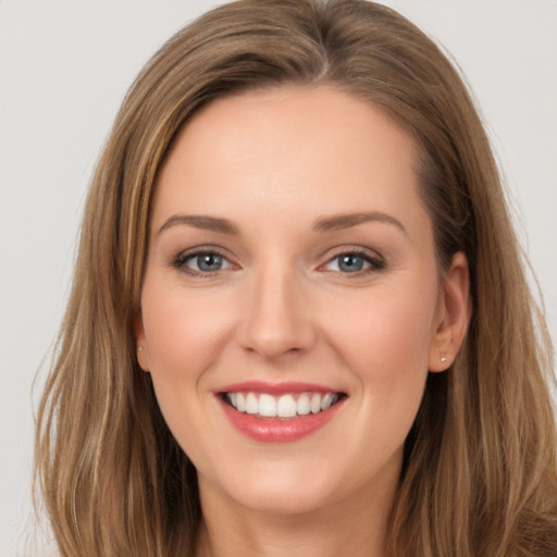 Joyful white young-adult female with long  brown hair and grey eyes