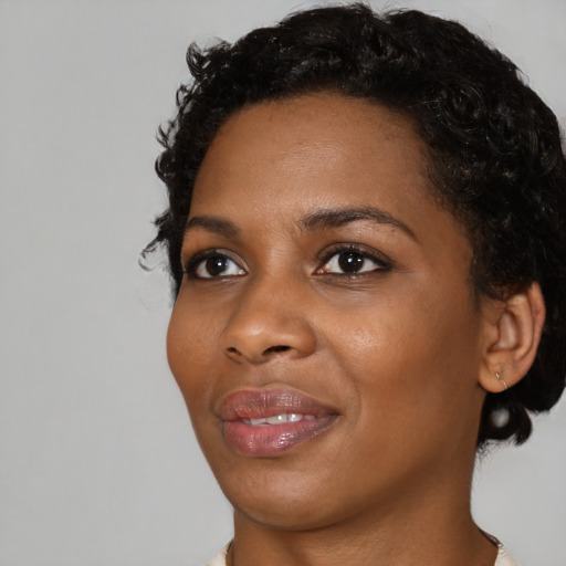 Joyful black young-adult female with short  black hair and brown eyes