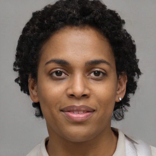 Joyful black young-adult female with short  black hair and brown eyes