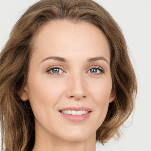 Joyful white young-adult female with long  brown hair and green eyes