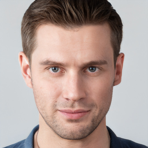 Joyful white young-adult male with short  brown hair and grey eyes