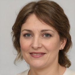 Joyful white adult female with medium  brown hair and grey eyes