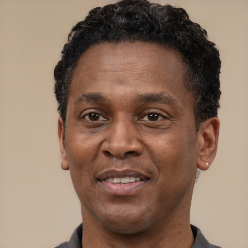 Joyful black adult male with short  black hair and brown eyes