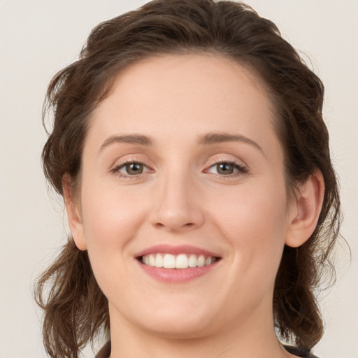 Joyful white young-adult female with long  brown hair and green eyes