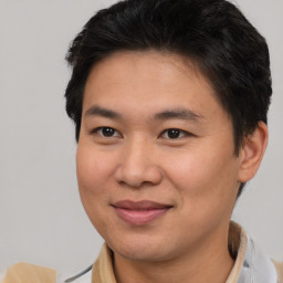 Joyful asian young-adult male with short  brown hair and brown eyes