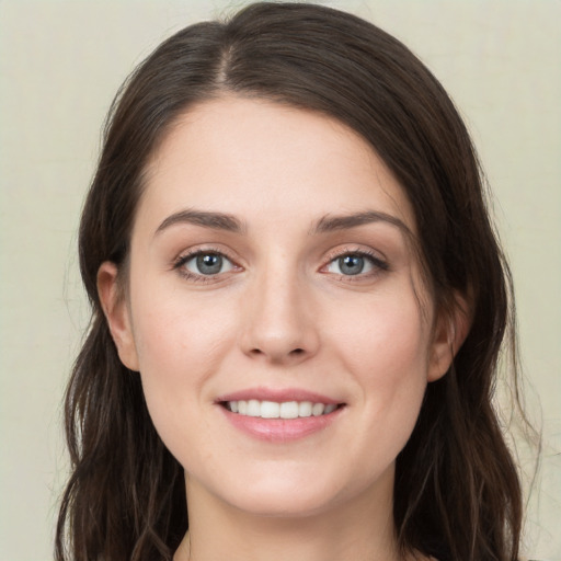 Joyful white young-adult female with long  brown hair and green eyes