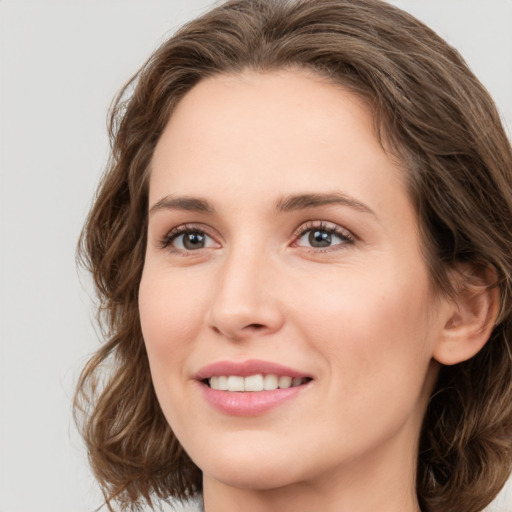 Joyful white young-adult female with medium  brown hair and green eyes