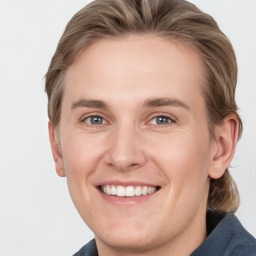 Joyful white young-adult male with medium  brown hair and grey eyes